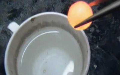 Tirando una bola de níquel al rojo vivo al agua