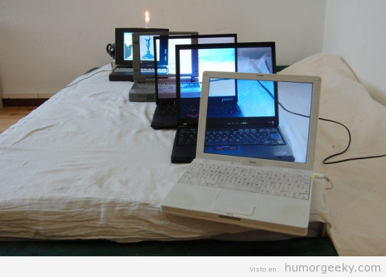 Foto de un nerd con todos sus ordenadores portátiles juntos