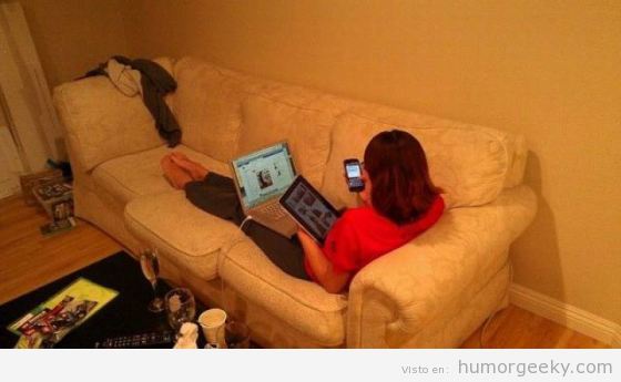 Foto de chica geek en el sofá con ordenador, tablet y móvil