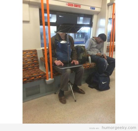 Hombre multitarea en el metro con ordenador y bebé