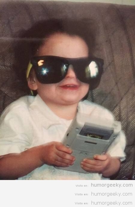 Foto graciosa niño con cara feliz y su primera Game Boy